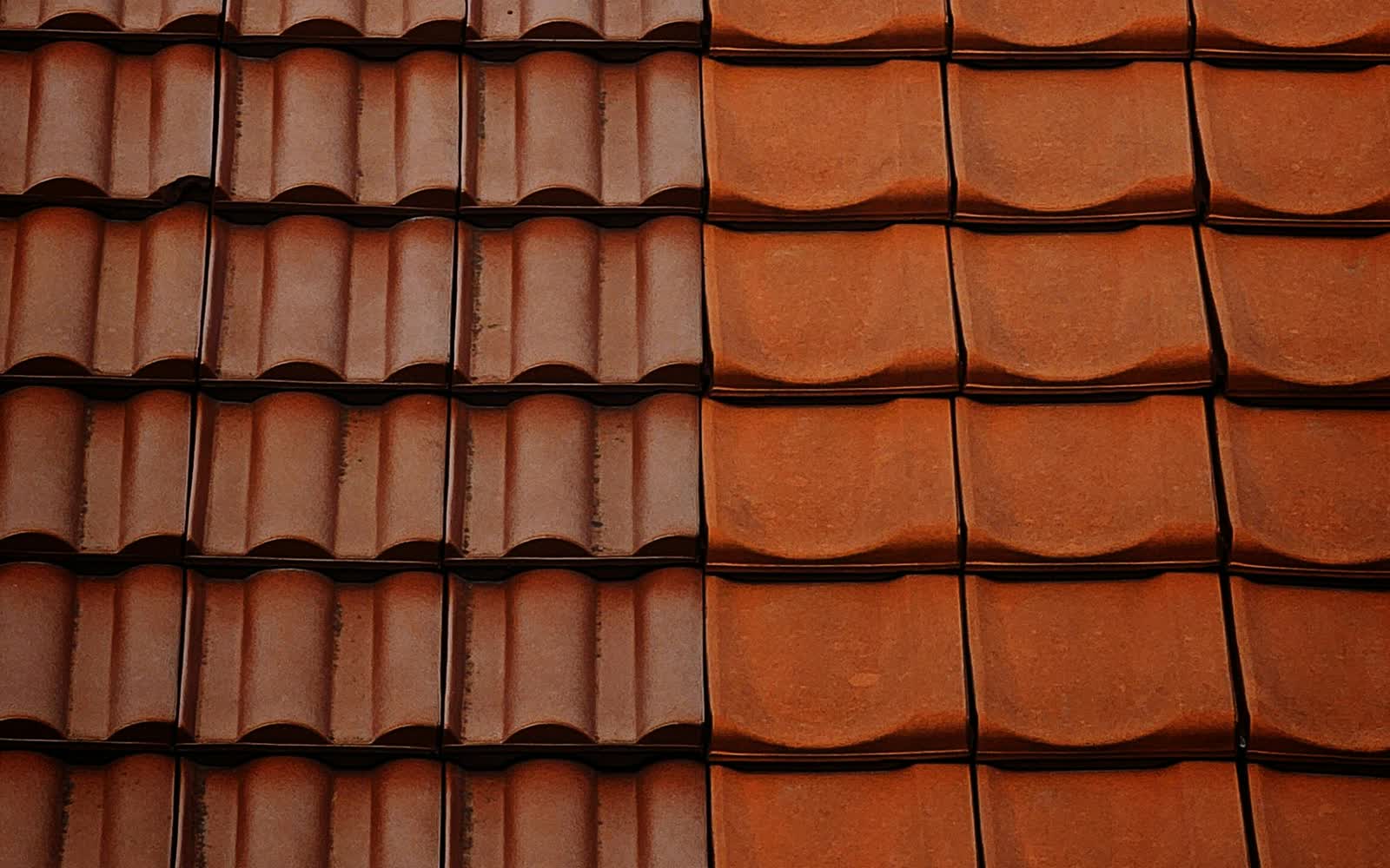 Brand-new red clay pantile roof — crisp, uniform tiles after a full re-roof